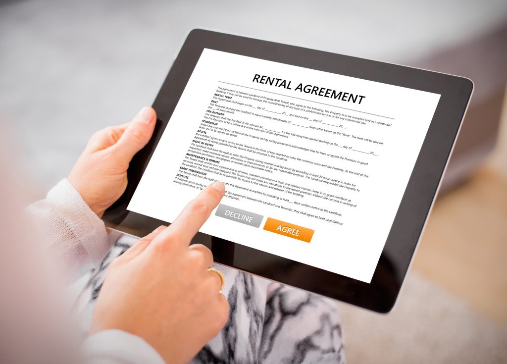 Woman reading rental agreement on tablet, photo taken from above.